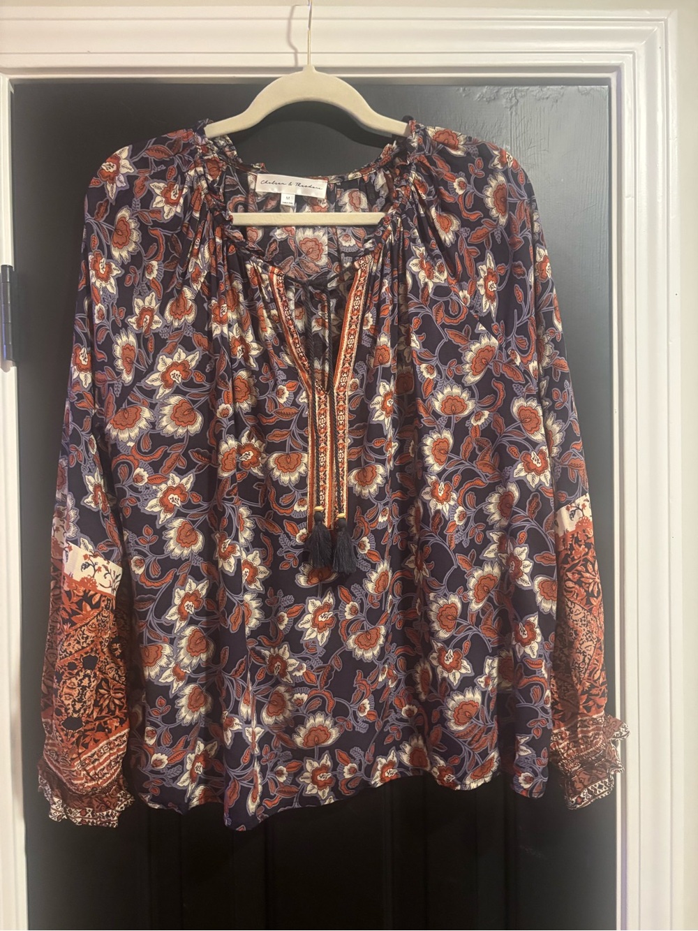 Chelsea & Theodore Navy Floral Tassel Tie Blouse. Great transition top .
